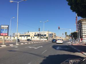una calle de la ciudad con semáforos y coches en la carretera en Cozy Jabotinsky Studio in Ashdod, en Ashdod