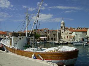 a boat is docked at a dock in the water at Apartments kod Ilje i Seke in Prvić Šepurine
