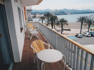 a balcony with a table and chairs and a view of the water at Apartamentos Mediterranean View in Llança