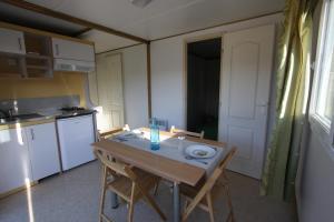 eine Küche mit einem Tisch mit Stühlen und einem Tisch sowie eine Küche in der Unterkunft Camping du Villard in Thorame-Basse