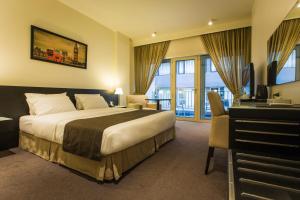 a hotel room with a bed and a desk and a television at Hotel Cavalier in Beirut