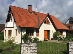 a white house with an orange roof at Ferienwohnung Störblick Schwerin in Raben Steinfeld