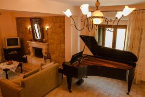 AgnítsiniにあるGarnelis Houseのリビングルーム(ピアノ、ソファ付)