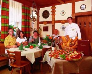 um grupo de pessoas sentadas numa mesa num restaurante em Hotel Post em Nordhalben