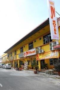 a yellow building with a sign in front of it at JV Hotel @ Bandar Tasek Mutiara in Simpang Ampat