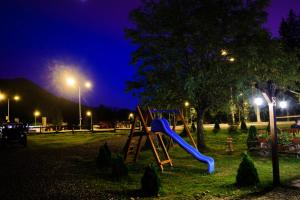 a playground with a slide in a park at night at Casa Vlasin in Poiana Brasov