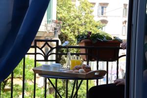 ローマにあるアデリーナ ゲストハウスのバルコニーのテーブルに食料品のトレイ
