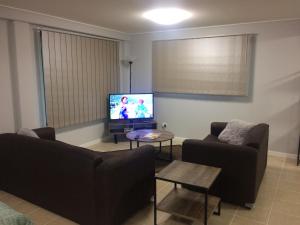 a living room with a couch and a tv at Stretton Lane in Townsville