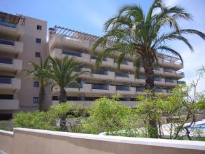 a building with palm trees in front of it at Descansa Y Disfruta De Las Mejores Playas in Arenales del Sol