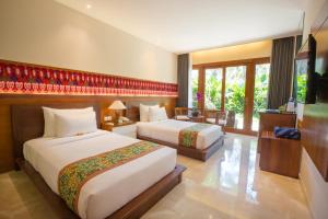 a hotel room with two beds and a television at Ubud Wana Resort in Ubud