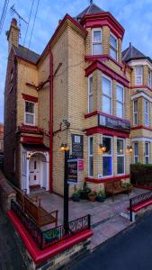 un gran edificio de ladrillo con un cartel delante en Happy Days Guesthouse, en Bridlington