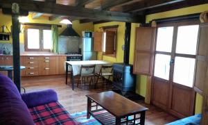 a living room with a couch and a table and a kitchen at Casa del Pinar in Enciso