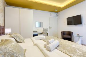 una camera con 2 letti e una TV a schermo piatto di Luxury Rooms Floramye a Spalato (Split)