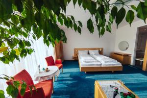 a bedroom with a bed and chairs and a tree at Hotel Klinglhuber in Krems an der Donau