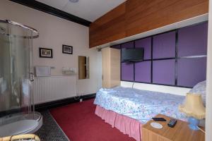a bedroom with a bed and a tub and a sink at Happy Days Guesthouse in Bridlington