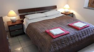 - une chambre avec un grand lit et 2 serviettes dans l'établissement Casa Giardino, à Spotorno