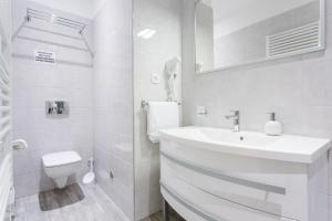 a white bathroom with a sink and a toilet at Luxury Rooms Floramye in Split