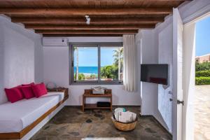 a living room with a couch and a television at Almyra Seaside Houses in Hersonissos