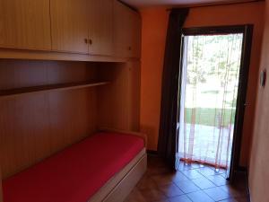a small room with a bed and a window at Green House in Pieve di Teco