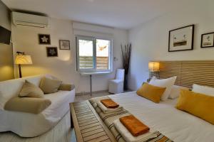 ein Wohnzimmer mit einem großen weißen Bett und einem Sofa in der Unterkunft Les Chambres d'Hôtes du Grand Mornas in Carry-le-Rouet