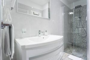 a white bathroom with a sink and a shower at Luxury Rooms Floramye in Split