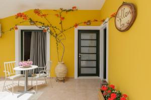 a dining room with a table and a clock on the wall at Yellow house in Parga