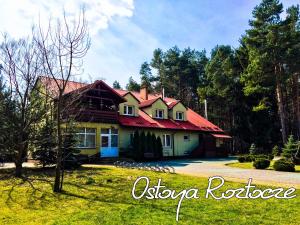 ein Haus mit rotem Dach auf einem Hof in der Unterkunft Ostoya Roztocze in Szczebrzeszyn