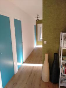 a room with two vases on the floor and a hallway at Bois de Kador in Morgat