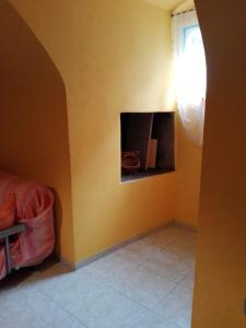 1 dormitorio con pared amarilla y chimenea en Appartamento Gallipoli, en Gallipoli