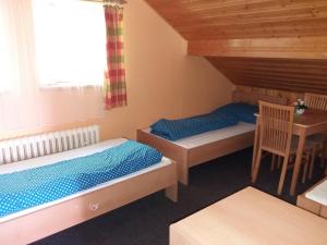 a room with two beds and a table and a window at Ski & Bike Špičák in Železná Ruda