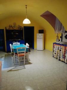 cocina con mesa azul y nevera blanca en Appartamento Gallipoli, en Gallipoli
