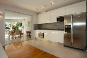 a kitchen with white cabinets and a stainless steel refrigerator at Deluxe apartment Lea with large garden in Split