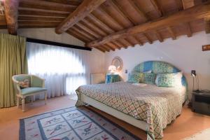 a bedroom with a bed and a chair at Tamerici Holiday Home by VacaVilla in San Miniato +36 photos