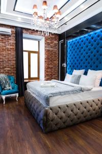 une chambre avec un grand lit et une tête de lit bleue dans l'établissement Theatre Boutique Apart-Hotel, à Kiev