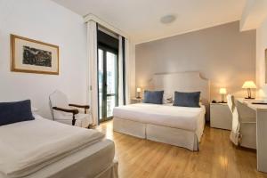 a hotel room with two beds and a desk at Hotel Byron Bellavista in Lido di Jesolo +31 photos