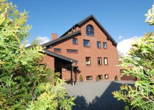 a brick building with trees in front of it at Haus über den Dächern von Heiligenhafen in Heiligenhafen