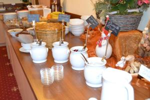 un buffet con tazas blancas y platos en una mesa en Häuslerhof, en Maranza