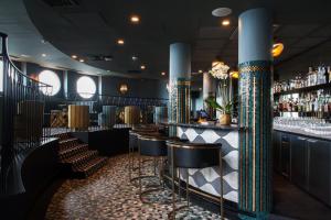 a bar with a row of stools and columns at Castelbrac Hotel & Spa in Dinard