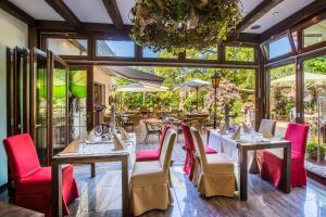 a restaurant with tables and chairs and a chandelier at Burgdorfs Hotel & Restaurant in Hude