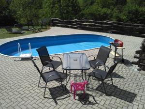 a group of chairs and a table in front of a pool at Apartmány Javorek in Sněžné