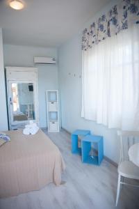 1 dormitorio con cama y mesa azul en Affittacamere Marzamemi, en Marzamemi
