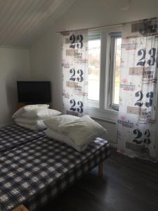 a bedroom with a bed with two pillows and a window at Seaview Cottage Solvik - Kungshamn in Kungshamn