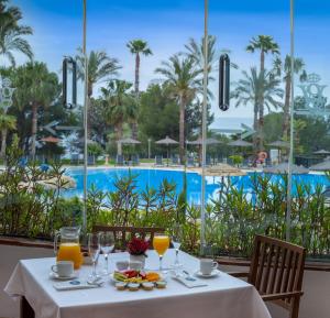 a table with drinks and fruit on a table with a view of a pool at SH Villa Gadea in Altea