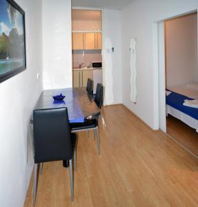 a dining room with a table and chairs and a bedroom at Meri Apartment in Rijeka