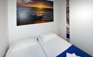 un sofá blanco en una habitación con una foto en la pared en Meri Apartment, en Rijeka