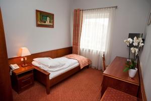 a bedroom with a bed and a table and a window at Eurohotel Swarzędz in Swarzędz