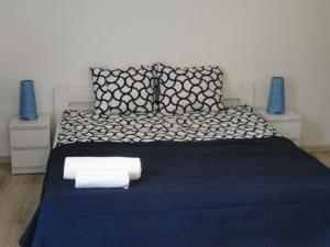 Un dormitorio con una cama azul con toallas. en Port przy Zeglarskiej en Ruciane-Nida