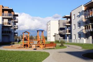 a playground in a park with two apartment buildings at Dream Apartment in Suwałki