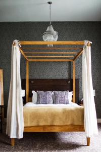 a bedroom with a wooden bed with a canopy at The Blue Boar in Witney