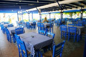 a dining area with blue tables and blue chairs at Galazio Limani - Rooms to let in Moúdhros +37 photos